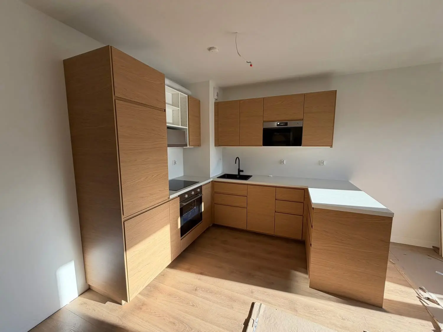 Handleless greige kitchen with black appliances